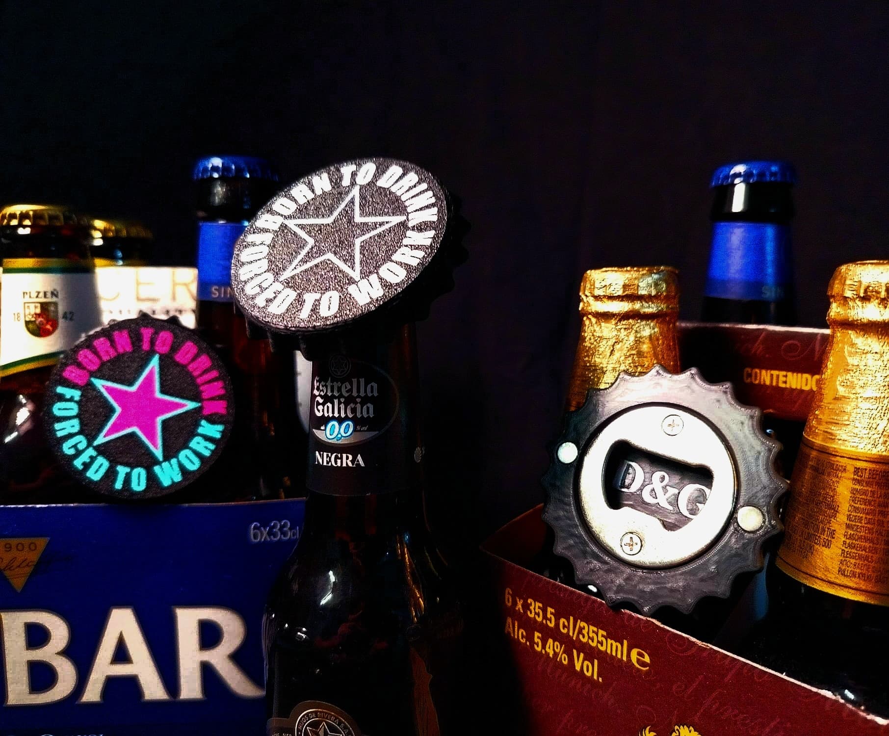 Abrebotellas circulares con una estrella y el lema Born to Drink Forced to Work, sobre packs de cerveza